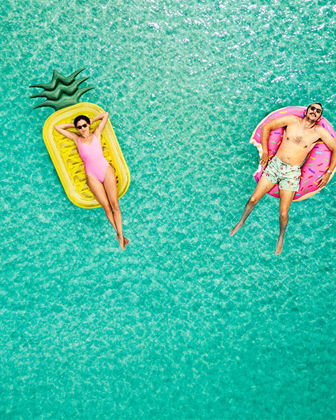 Personen auf Luftmatratzen im Wasser